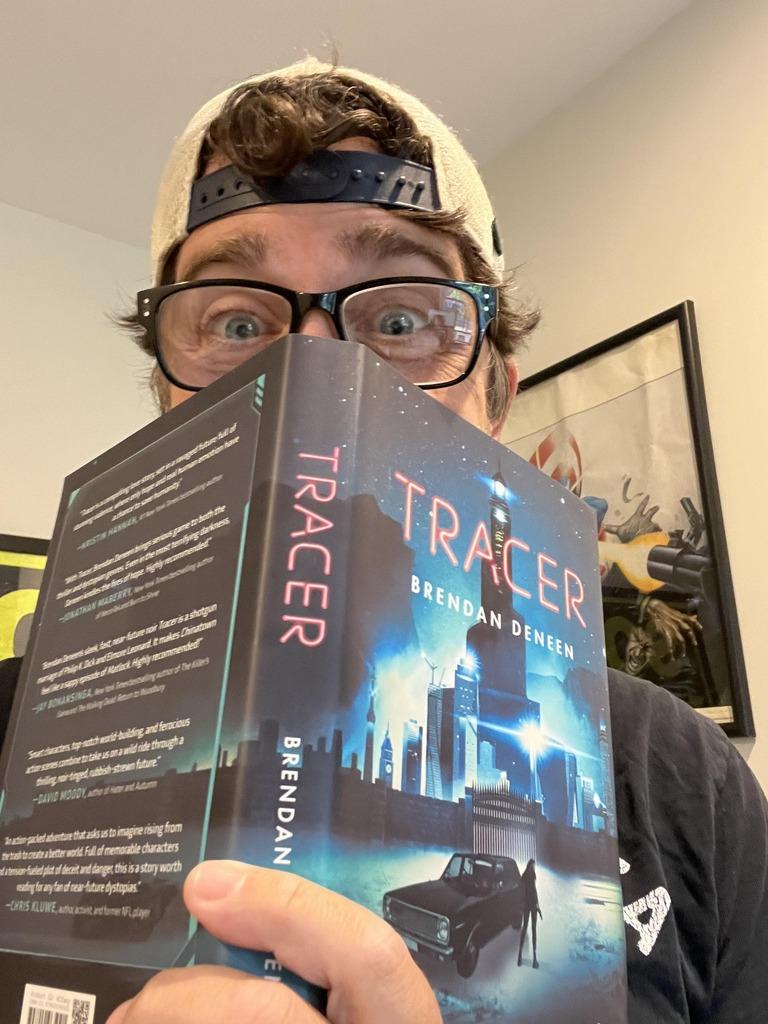 Author Brendan Deneen with a copy of his latest novel, TRACER.